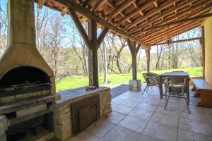 un patio al aire libre con chimenea, mesa y sillas en Gite Les genêts, baronnies provençales, en Montjay