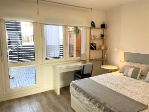 Un dormitorio con una cama y un escritorio y una ventana. en 4 Apartamentos de Autor, en Lugo