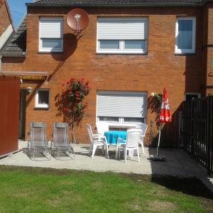 eine Terrasse mit einem Tisch und Stühlen vor einem Haus in der Unterkunft Ferienhaus Middenmank in Emden