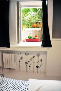 メスにあるAppartement Meublé Type T2の花が壁に描かれた窓付きのベッドルーム1室
