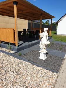 a statue of an angel sitting in a garden at Andromachi Apartments in Jembke