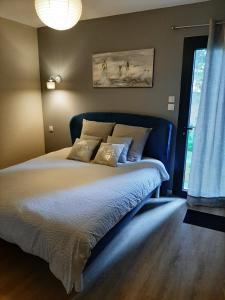 a bedroom with a large bed with a blue headboard at La Villa Claudia Jardin et Spa in Pennautier