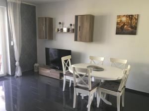 a dining room with a table and chairs and a tv at Feriendomizil im Musikerviertel in Otterndorf in Otterndorf
