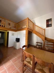 una sala de estar con una escalera de madera y una mesa en Appartements " Le Clos De La Cerisaie", en Castillon-du-Gard
