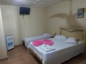 a room with two beds with pink bows on them at Hotel Super Economico in Vitória