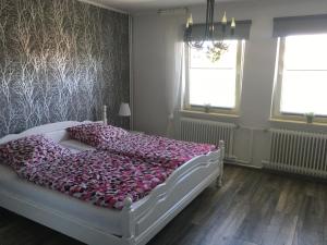 a bedroom with a white bed with pink pillows at Feriendomizil im Musikerviertel in Otterndorf in Otterndorf