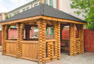 a wooden gazebo with a black roof at Apartamenty w Świeciu CS17 in Świecie