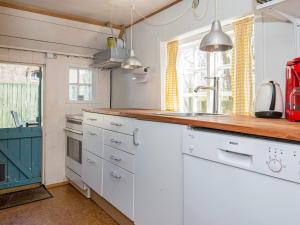 een keuken met witte kasten en een houten aanrecht bij 4 person holiday home in Fan in Fanø