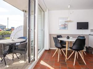 a dining room with a table and chairs on a balcony at 4 person holiday home in Fan in Fanø