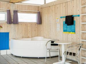 Sønderhoにある12 person holiday home in Fanのバスタブ、テーブル、椅子が備わります。