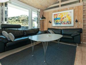 Sønderhoにある10 person holiday home in Fanのリビングルーム(黒い革張りのソファ、テーブル付)