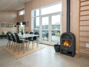 sala de estar con chimenea, mesa y sillas en 6 person holiday home in Bjert en Sønder Bjert