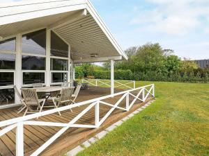 une terrasse couverte d'une maison avec une table et des chaises dans l'établissement 8 person holiday home in Lemvig, à Lemvig