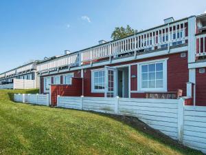 une maison rouge avec une clôture blanche devant elle dans l'établissement 6 person holiday home in Aabenraa, à Åbenrå