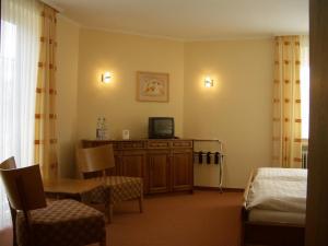 a room with a bedroom with a bed and a television at Hotel Ritschlay in Bollendorf