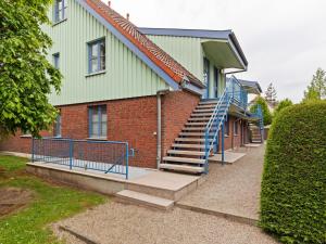 ein Backsteingebäude mit einer Treppe davor in der Unterkunft Spacious Apartment in Boltenhagen by the Sea in Boltenhagen