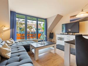 ein Wohnzimmer mit einem Sofa und einem TV in der Unterkunft Spacious Apartment in Boltenhagen by the Sea in Boltenhagen