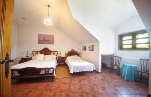 a bedroom with two beds and a table at Hotel Mar de Queo in Carballo