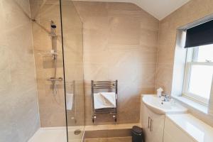 ein Bad mit einer Dusche und einem Waschbecken in der Unterkunft The Stay Company, Mill Street in Derby