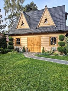 une maison en bois avec un toit en gambrel dans l'établissement Domek u Kubusia, à Białka Tatrzańska