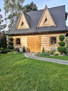 a wooden house with a gambrel roof at Domek u Kubusia in Białka Tatrzańska