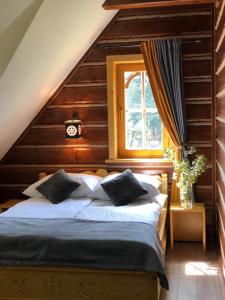 une chambre avec un grand lit avec une fenêtre dans l'établissement Domek u Kubusia, à Białka Tatrzańska