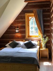 a bedroom with a large bed with a window at Domek u Kubusia in Białka Tatrzańska