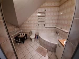 uma pequena casa de banho com banheira e WC em Apartament Lawenda em Międzyzdroje