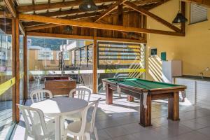 a room with a ping pong table and chairs at Bombinhas Praia Apart Hotel - unidade rua Bem Te Vi in Bombinhas