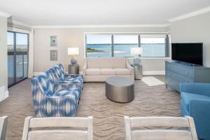 a living room with a couch and a tv at Bask Hotel at Big Rock Landing in Morehead City
