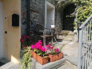 a patio with flowers and a table and chairs at La Ruota del Mulino in Nesso
