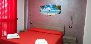 a bedroom with a red bed with two towels at Valeri 's Country House in Sperlonga