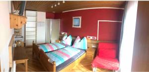 a bedroom with a bed and a red wall at Haus Waldrast in Filzmoos