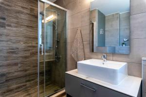 uma casa de banho com um lavatório e uma cabina de duche em vidro. em Big Blue suites 2 em Ierápetra