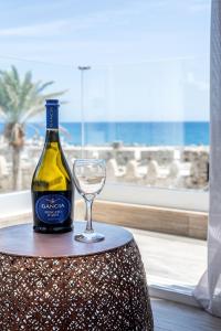 uma garrafa de vinho e um copo sobre uma mesa em Big Blue suites 2 em Ierápetra