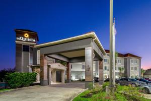 a front view of a hotel with a parking lot at La Quinta by Wyndham Boutte in Boutte