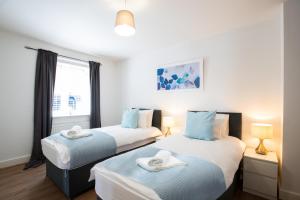 two twin beds in a room with a window at Velvet 1-bedroom apartment, Clockhouse, Hoddesdon in Hoddesdon