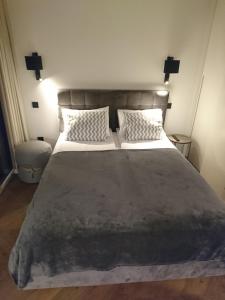 um quarto com uma cama grande e 2 almofadas em Kalno Studijos em Juodkrantė