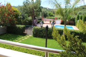 a garden with a swimming pool and a fence at Villa Alimedon in Almirida