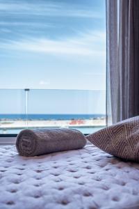 1 cama y 1 almohada en el suelo frente a una ventana en Big Blue suites 1, en Ierápetra