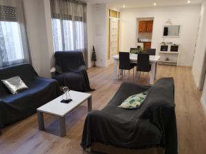 a living room with two couches and a dining room at Casa Serral in Deltebre