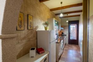 une cuisine avec un réfrigérateur blanc dans une pièce dans l'établissement Casa Rural El Olivo / El Almendro, à Aldeadávila de la Ribera