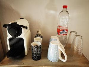 una mesa de madera con tazas y una botella de agua en Roca Verde, Boutique Bed & Breakfast, en Alhaurín de la Torre