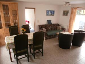 sala de estar con mesa, sillas y sofá en Ferienhaus Monika, en Mursewiek