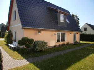 una casa con techo azul con un banco en el patio en Ferienhaus Monika, en Mursewiek