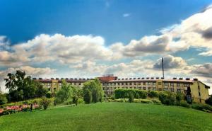 ein großes Gebäude mit einem grünen Feld davor in der Unterkunft Hotel 500 in Tarnowo Podgórne