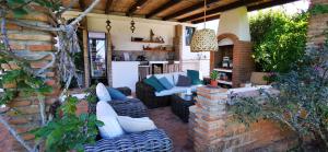 a patio with couches and chairs on a brick wall at Roca Verde, Boutique Bed & Breakfast in Alhaurín de la Torre