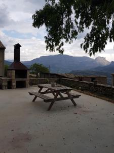 una mesa de picnic con vistas a las montañas en Casa Simon 2 en Roda de Isábena