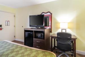 a hotel room with a bed and a desk with a television at SureStay Hotel by Best Western Brunswick in Brunswick