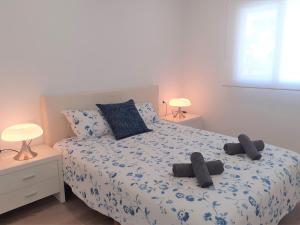 een slaapkamer met een bed met twee slippers erop bij FH COCOLISO I in Altea